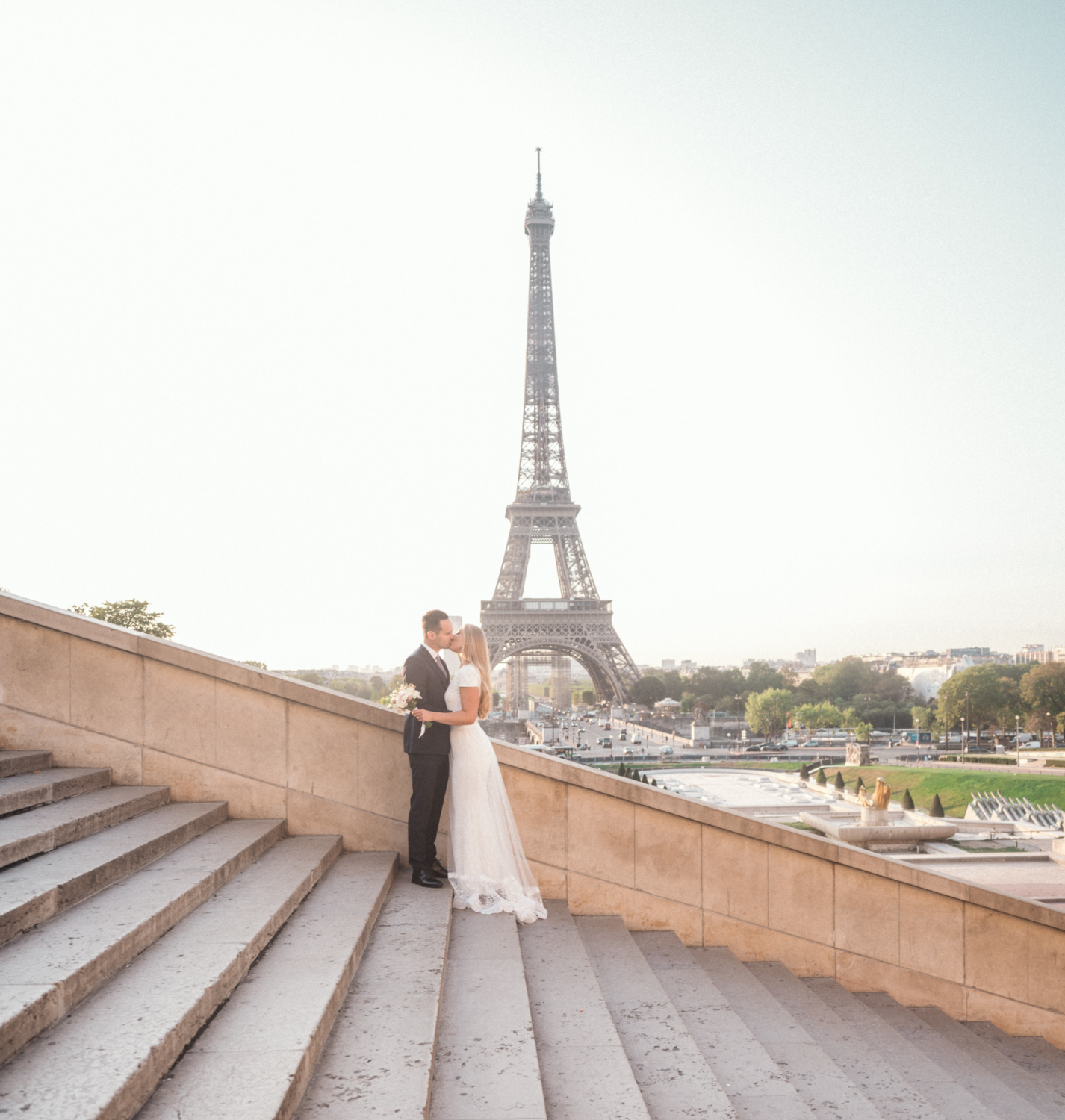 bride and groom kiss on steps at trocadero eiffel tower paris