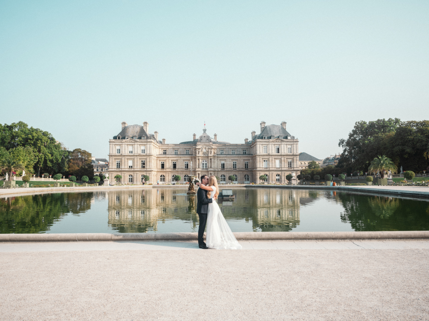 bride and groom passionately kiss in luxembourg gardens paris