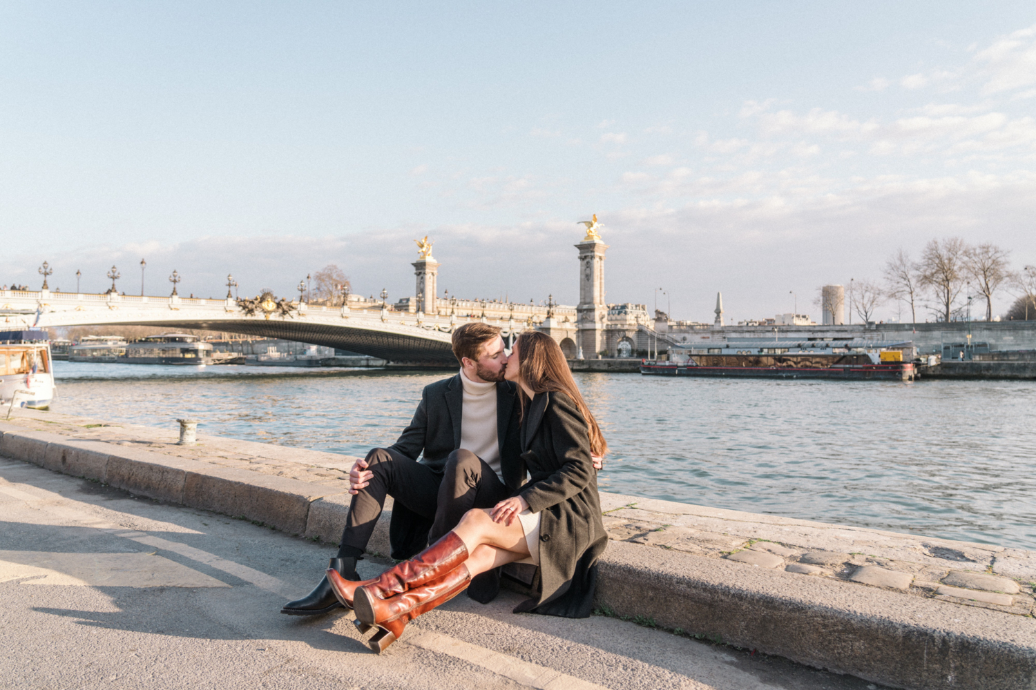 newly engaged couple kiss along the seine river in paris
