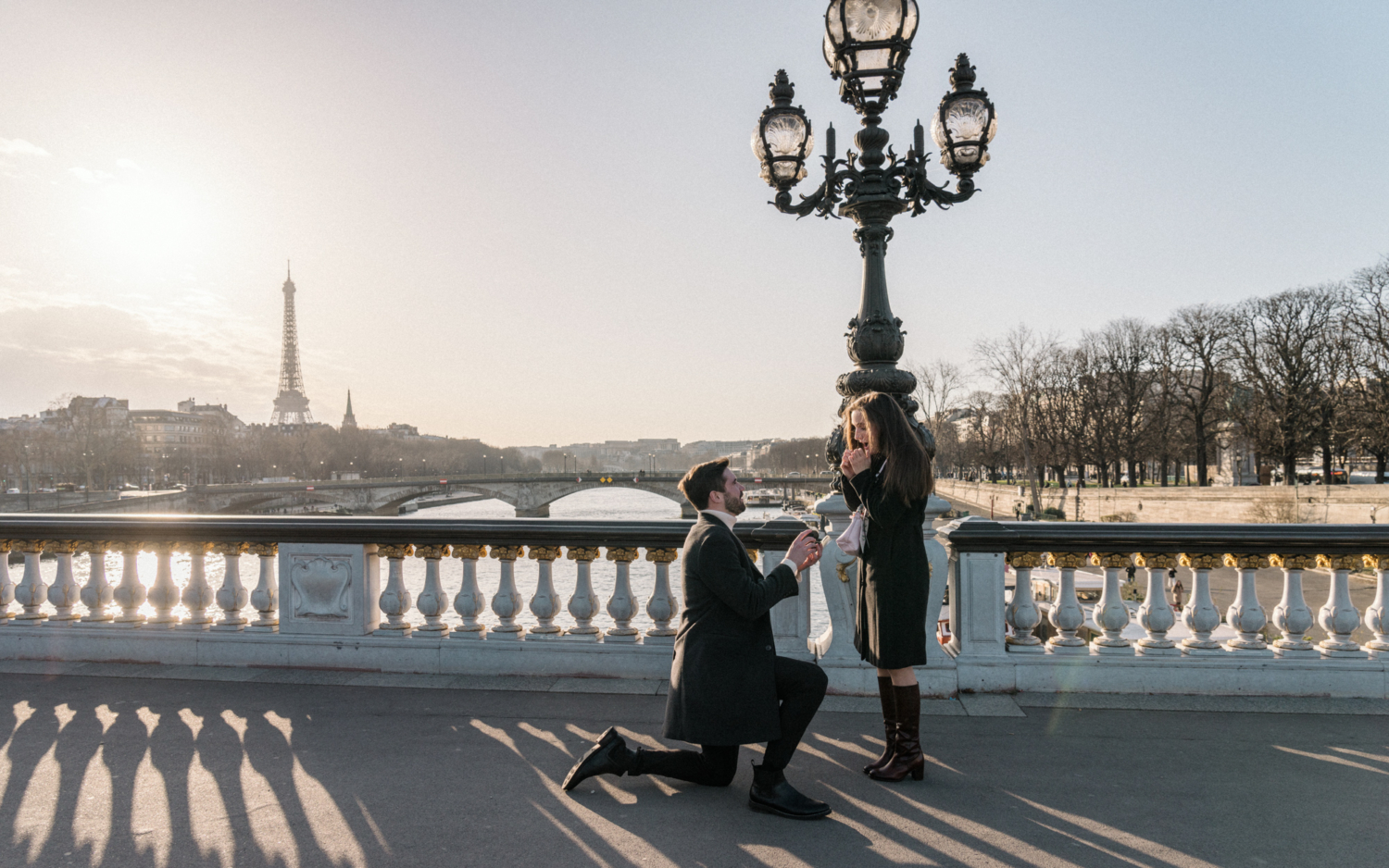 man proposes marriage to woman with view of eiffel tower