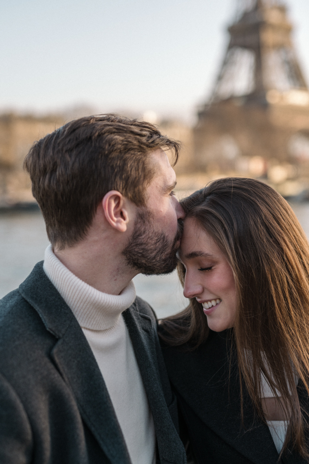 man kisses woman on forehead in paris