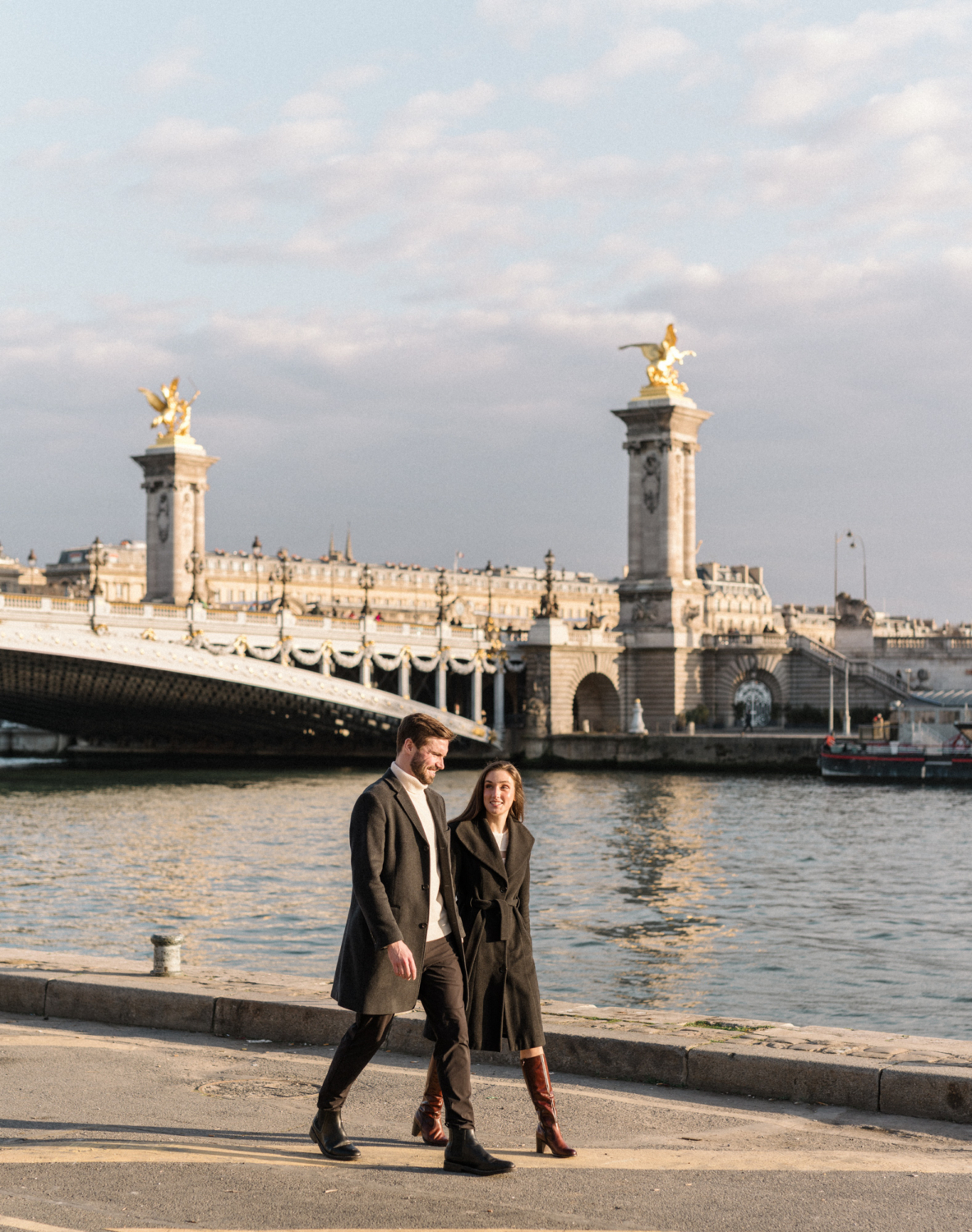 newly engaged couple walk in paris with pont alexandre in background