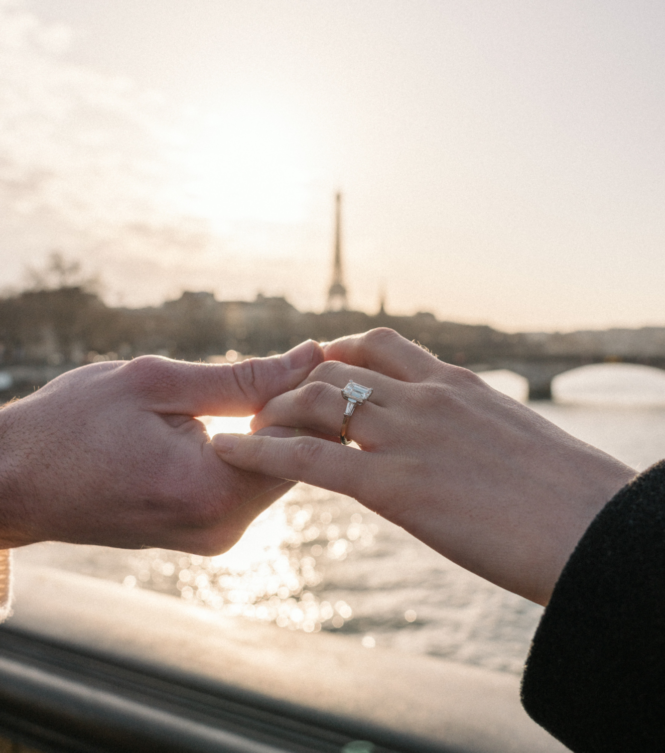 couple hold hands with engagement ring in paris