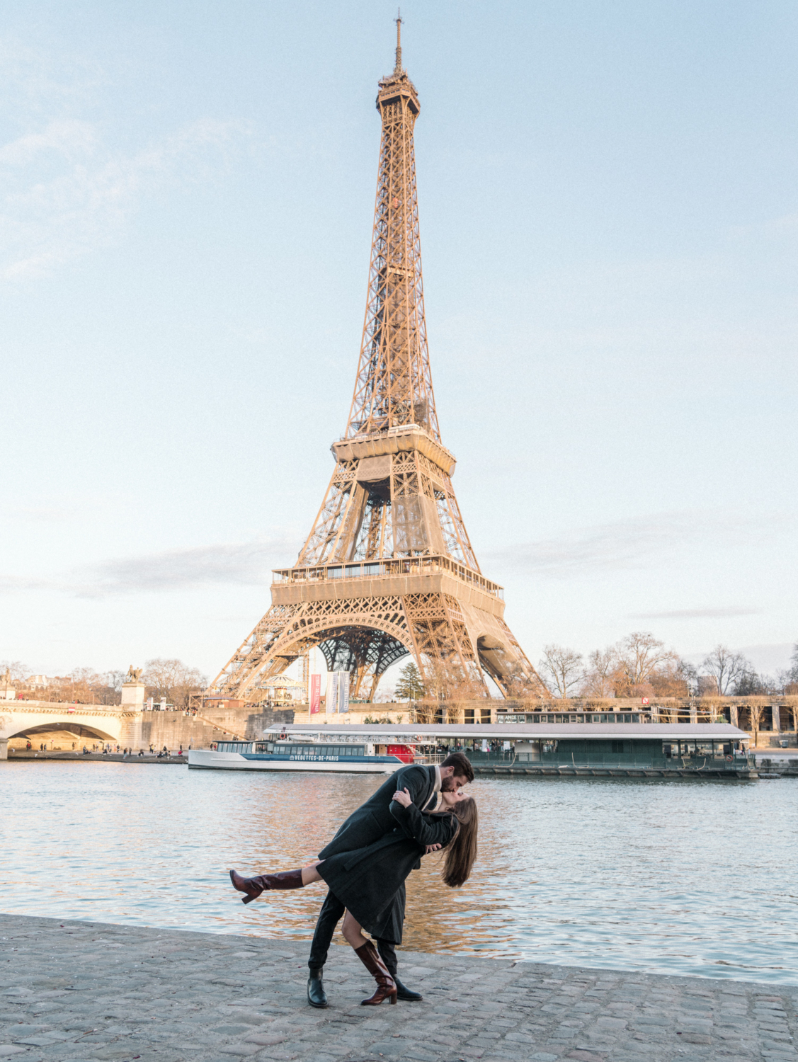 man dips woman and kisses her in paris at eiffel tower