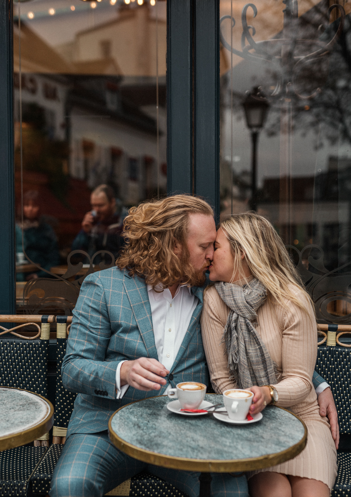 newly engaged couple kiss at cafre in montmartre in paris