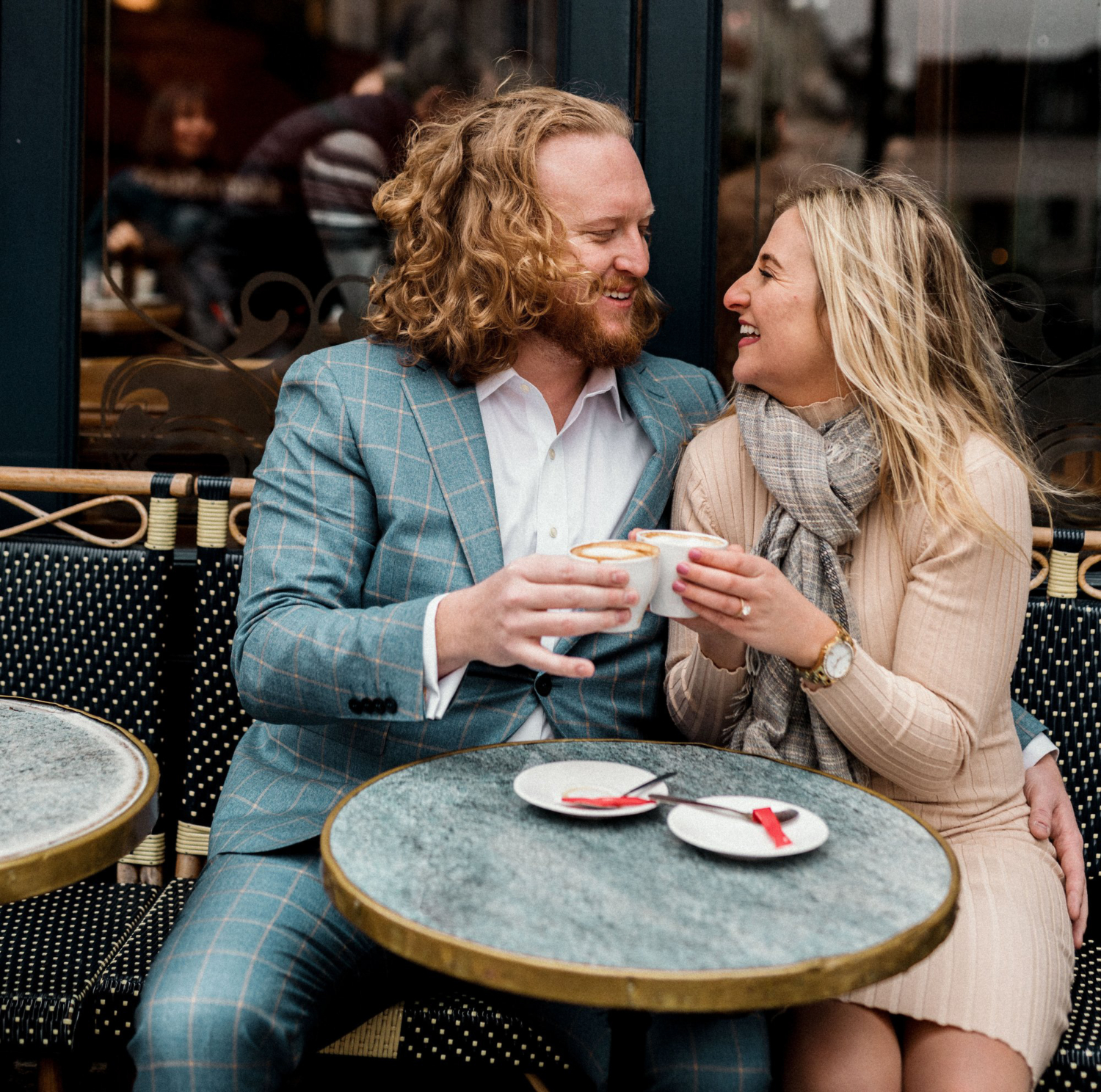 newly engaged couple hold coffee at a cafe in paris