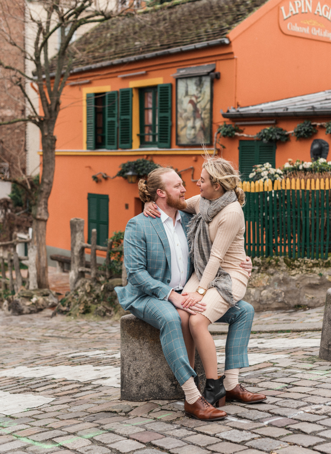 woman sits on mans lap in montmartre in paris