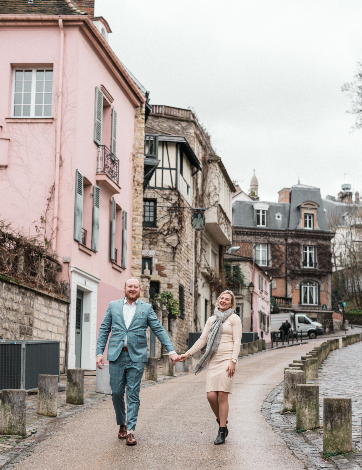 newly engaged couple walk on pretty street in montmartre paris