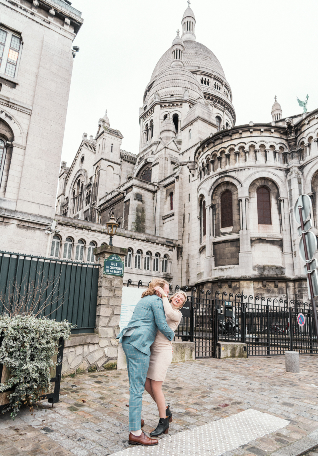 newly engaged couple laughs at sacre coeur basilica in paris