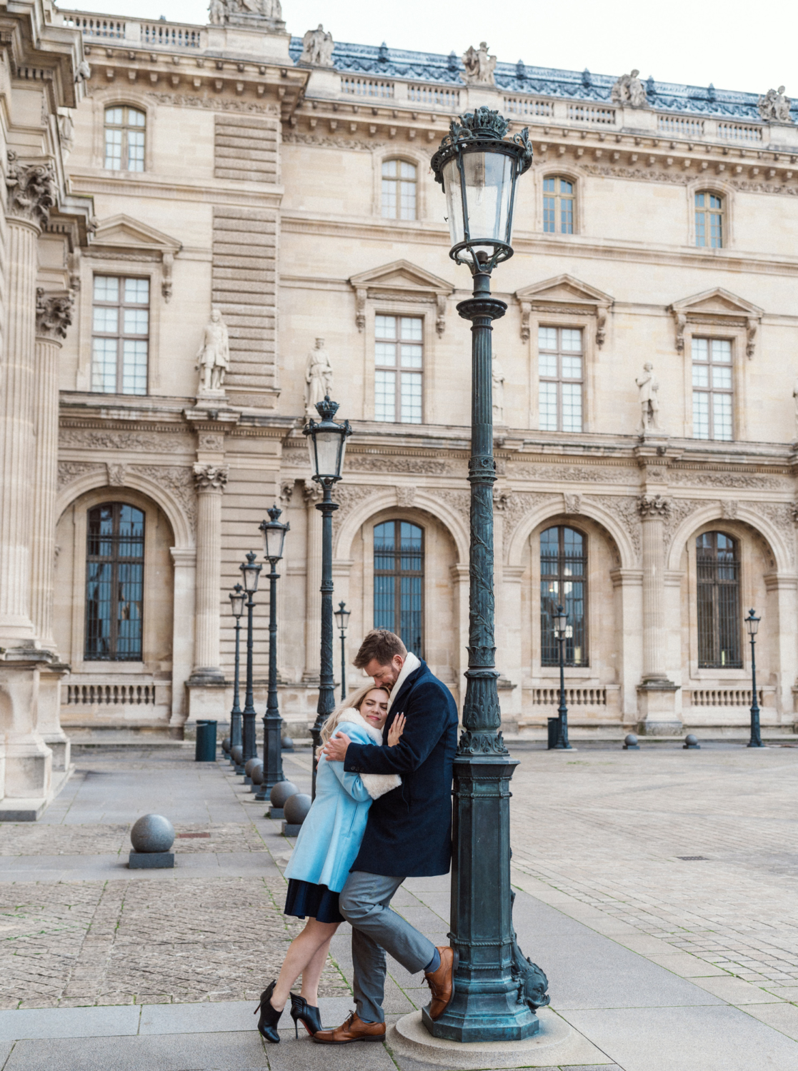 woman leans on man at the louvre in paris