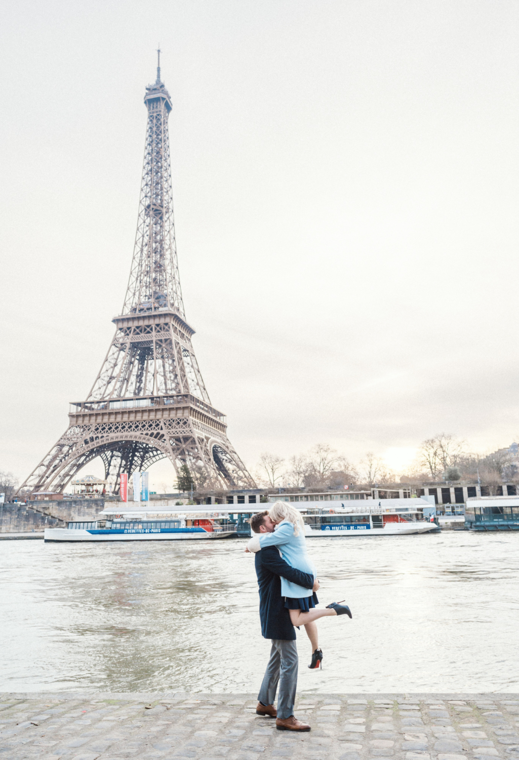 man lifts woman at eiffel tower in paris