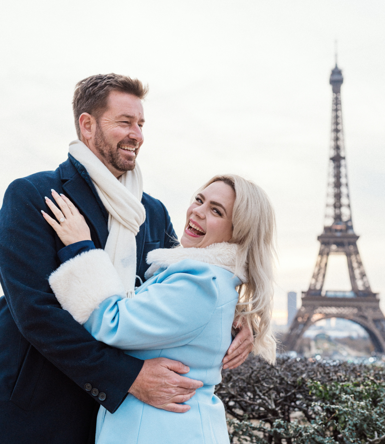 engaged couple laugh at the eiffel tower in paris