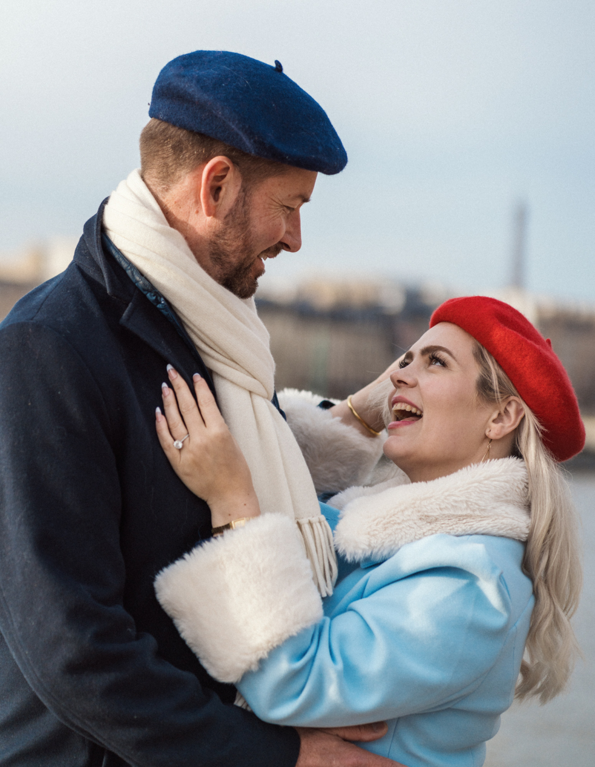 woman and man in berets laugh in paris