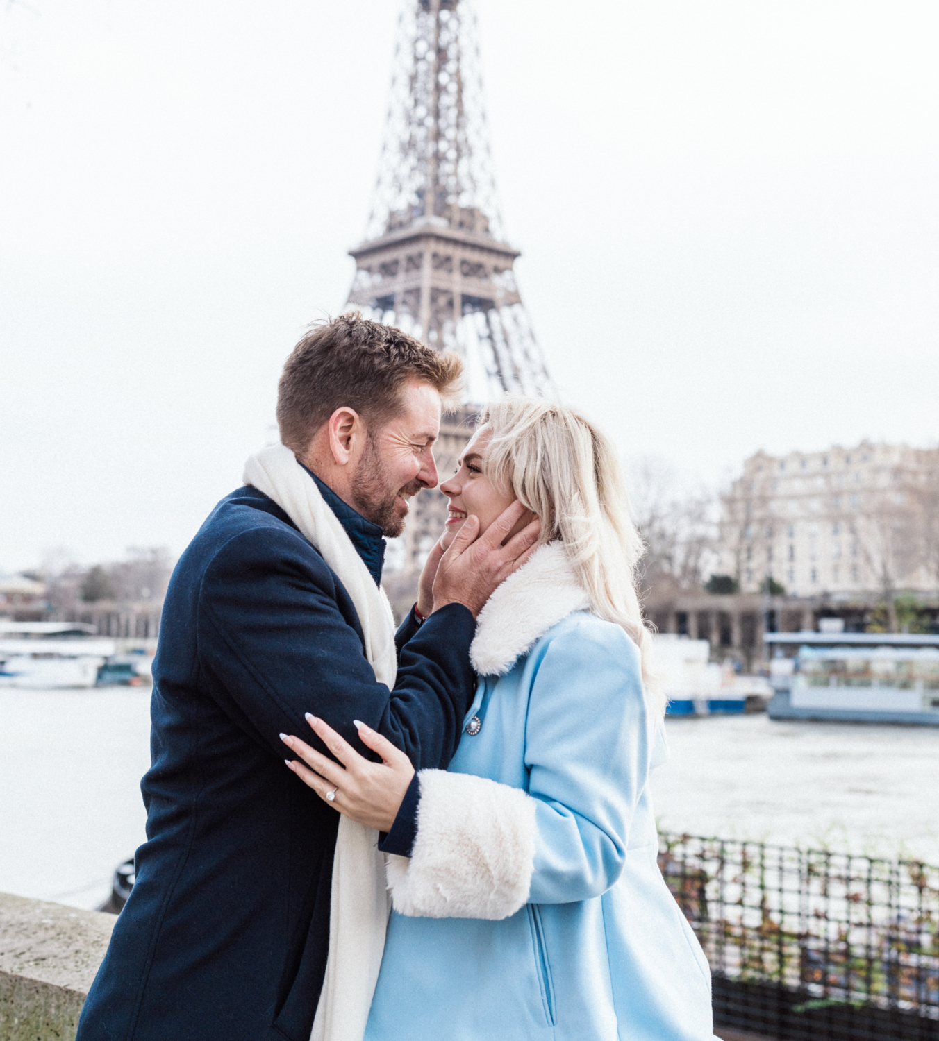 man grabs woman's cheeks with view of eiffel tower