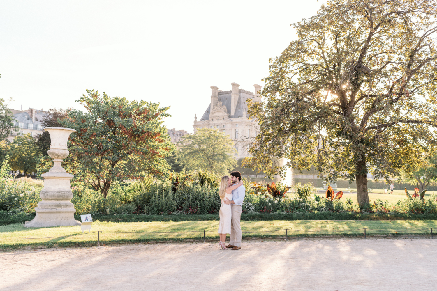 engaged young couple hug in the tuileries gardens in paris