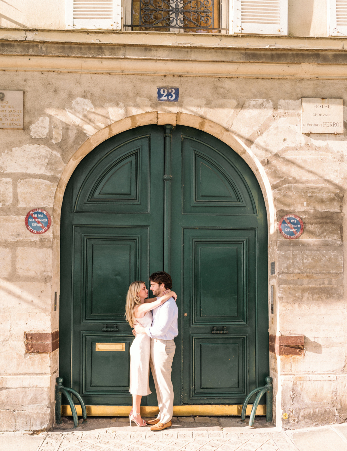 engaged young couple hug in front of green door in paris
