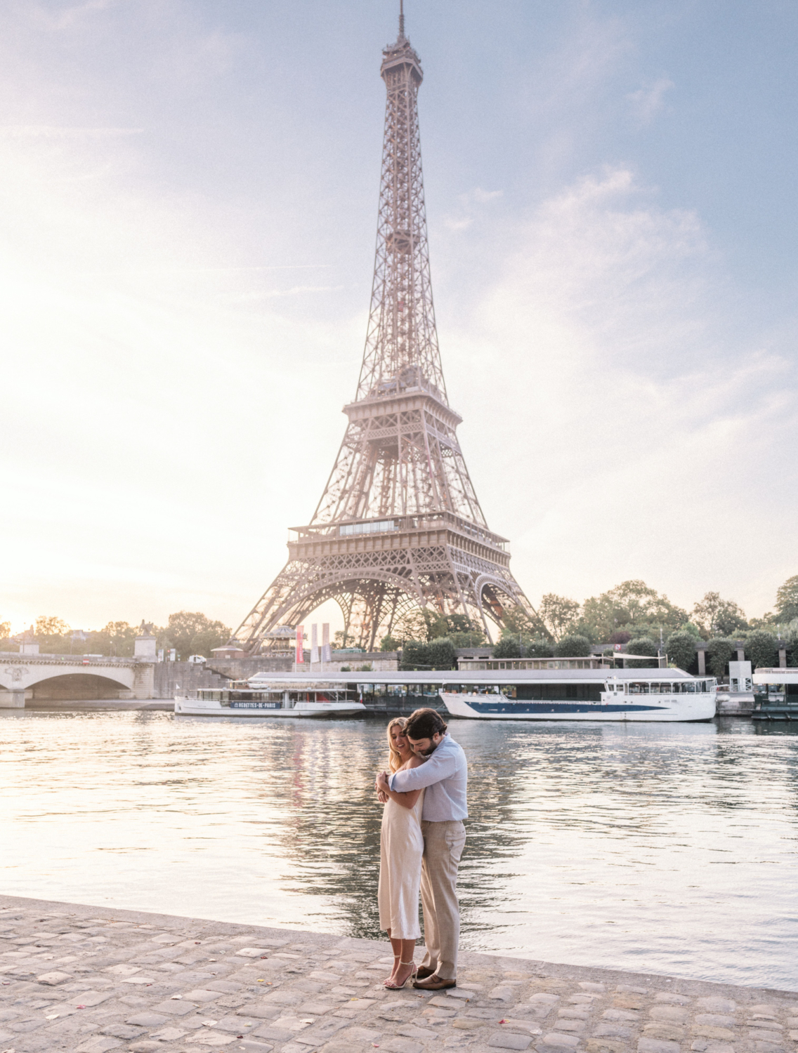 engaged young couple embrace at the eiffel tower paris