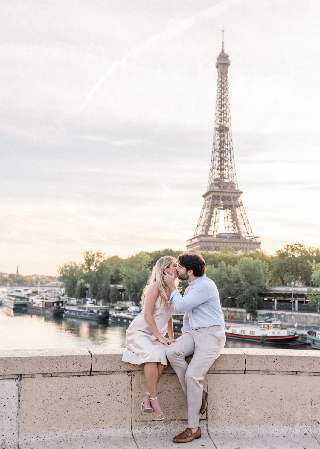 engaged young couple kiss passionately with a view of the eiffel tower