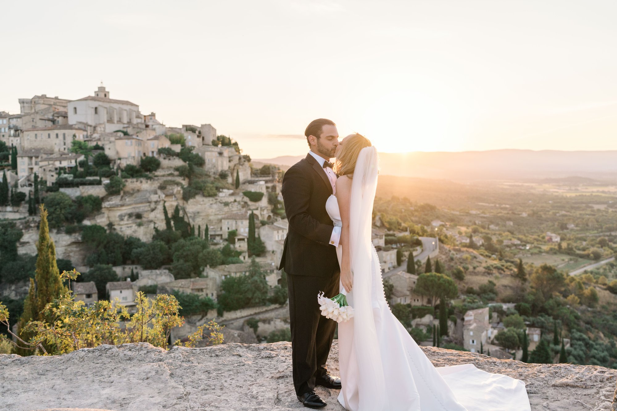 bride and groom kiss at sunrise in gordes france