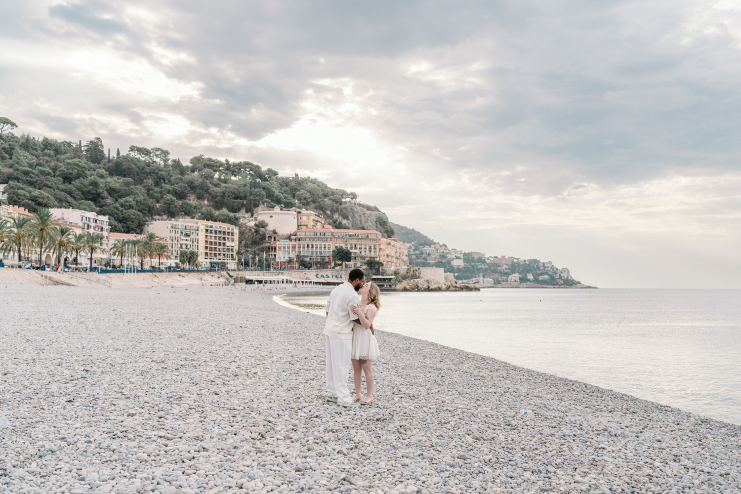 newly engaged couple kiss on stone beach in nice france