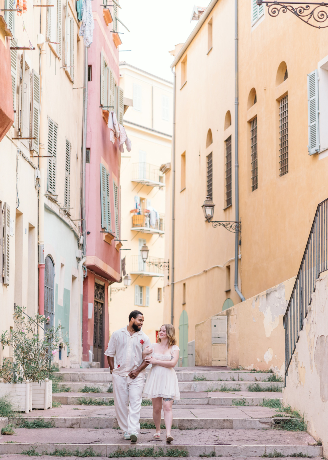 husband and wife walk together in colorful old neighborhood in nice france