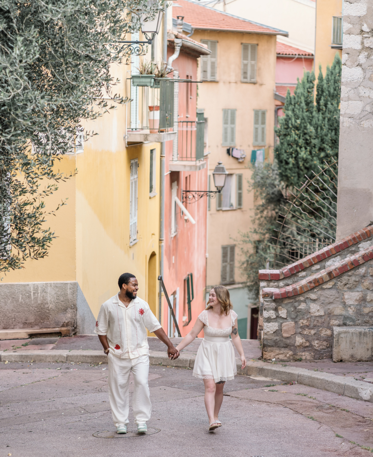 happy couple walk hand in hand in the streets of nice france