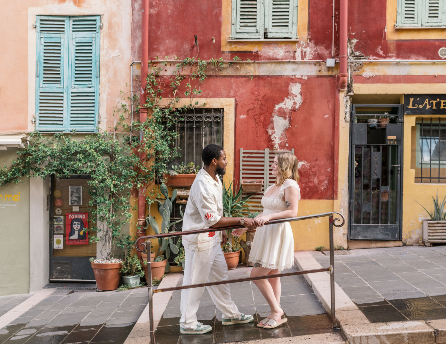 newlyweds pose in front of orange building in old nice france