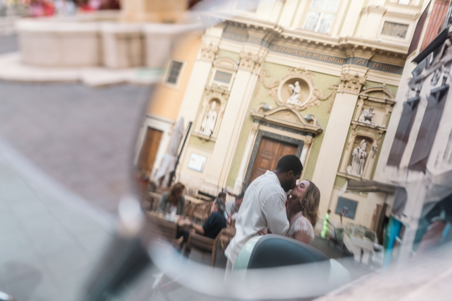 couple kiss passionately in mirror of vespa in nice france