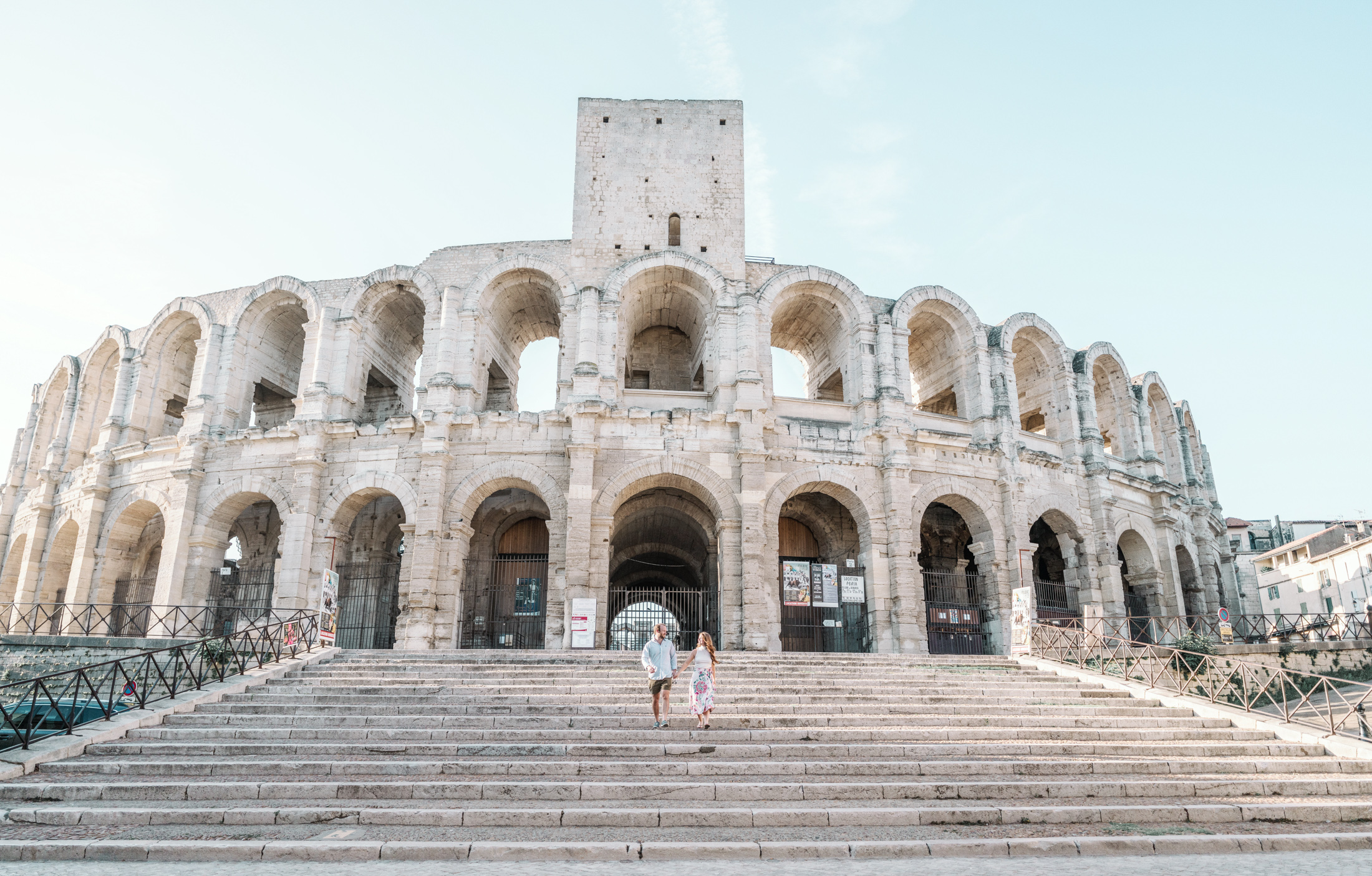 happy couple walk down the stairs of roman amphitheatre in arles france