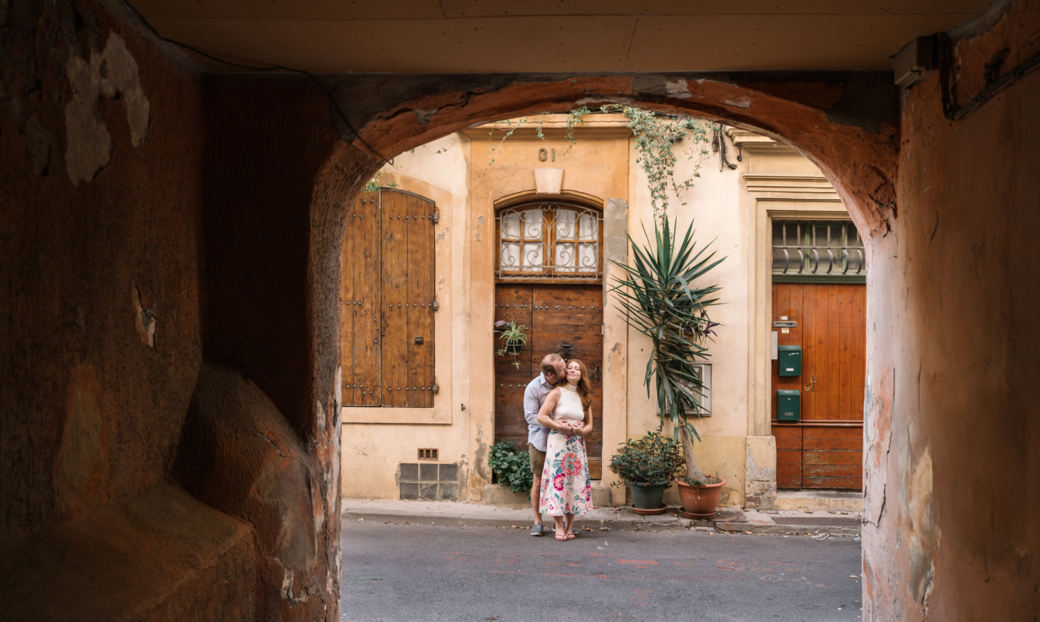 man kisses womans cheek in old village in provence