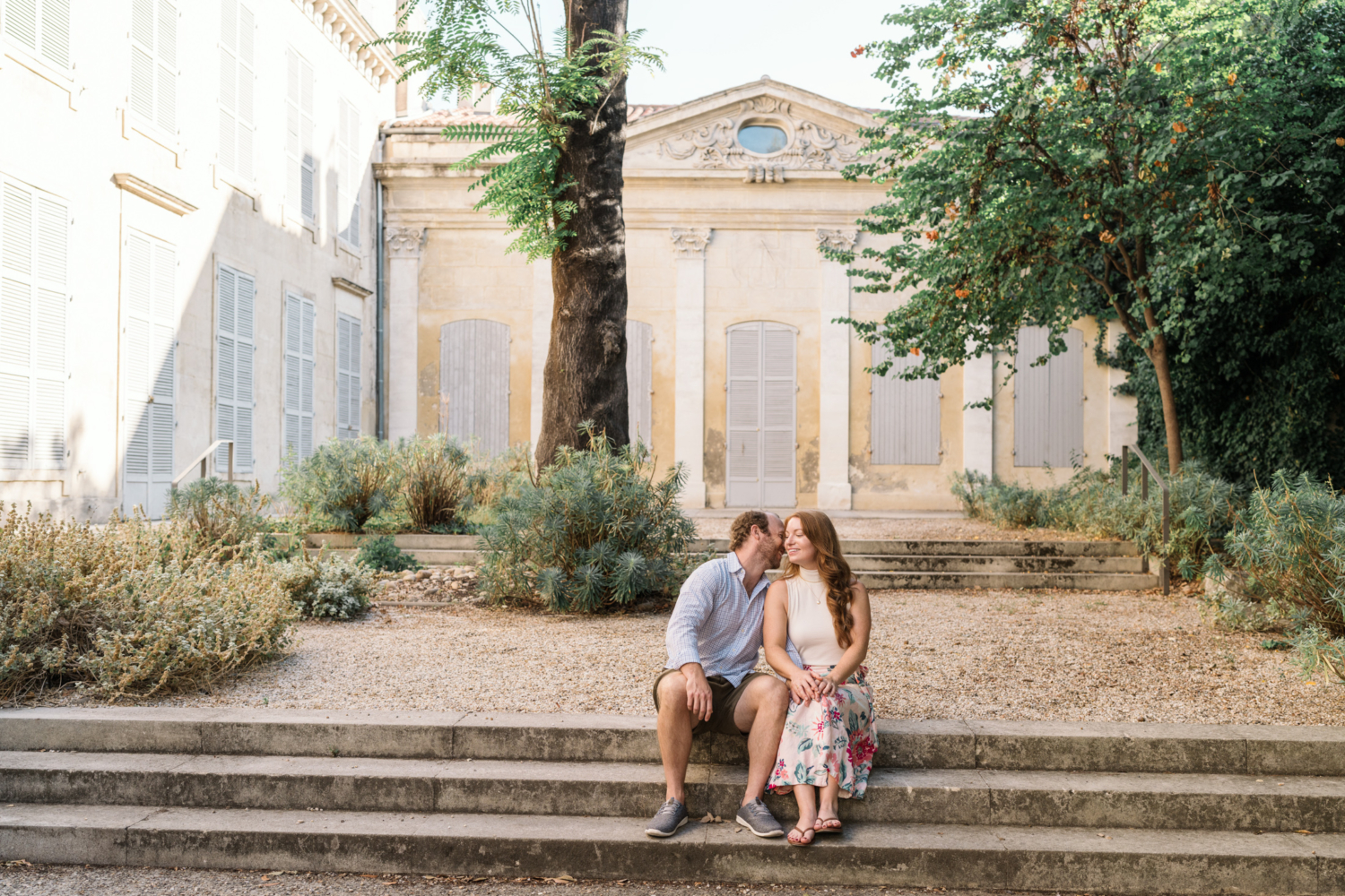 man tells woman a secret in garden in arles france