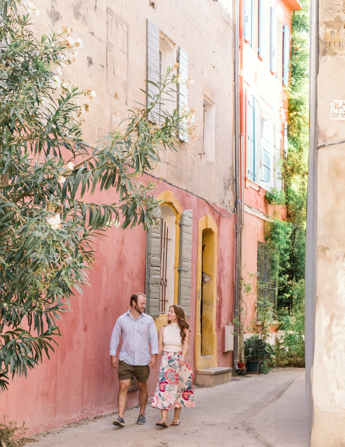 happy couple walk in colorful neighborhood in arles france