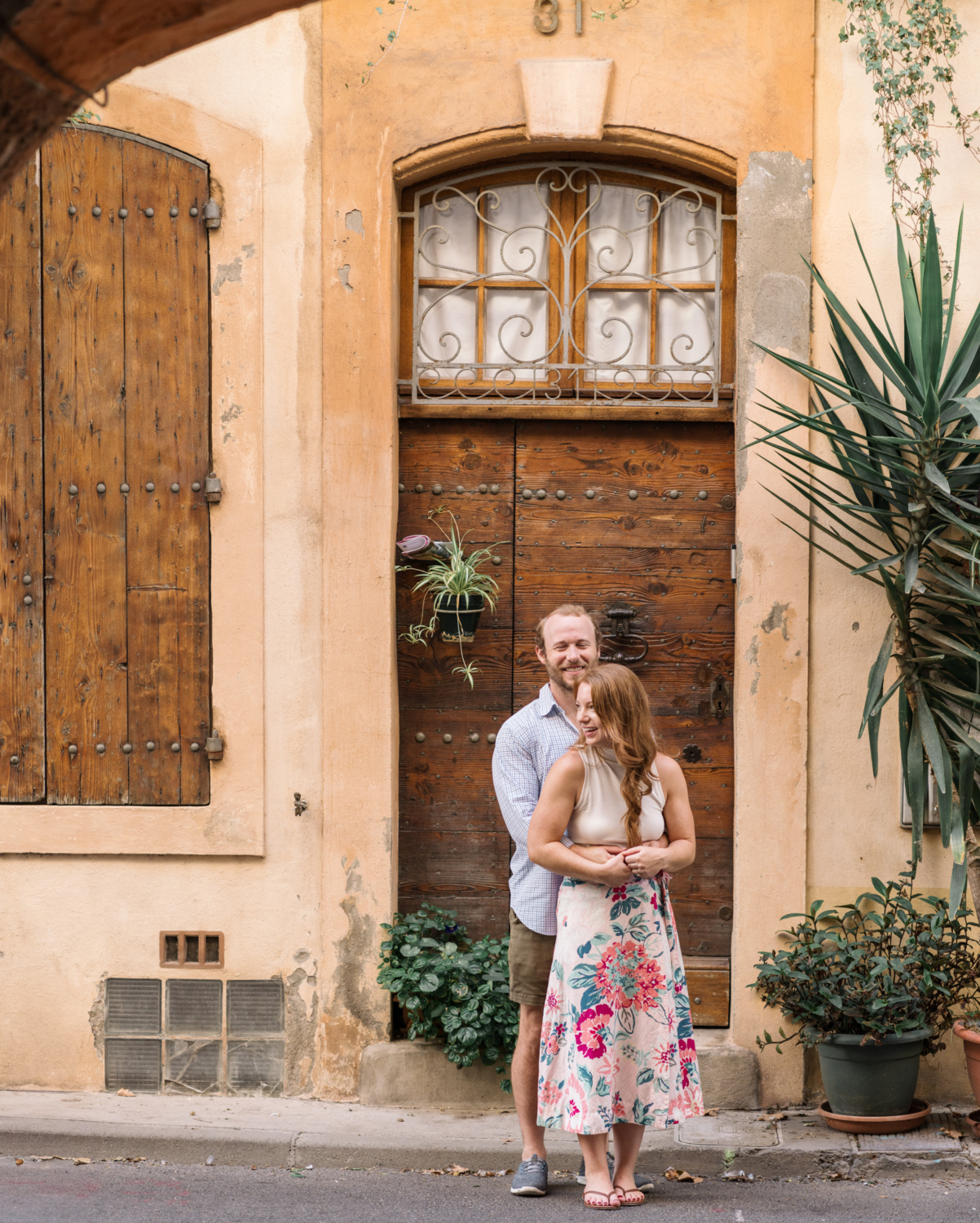 married couple laugh next to beautiful door in arles france