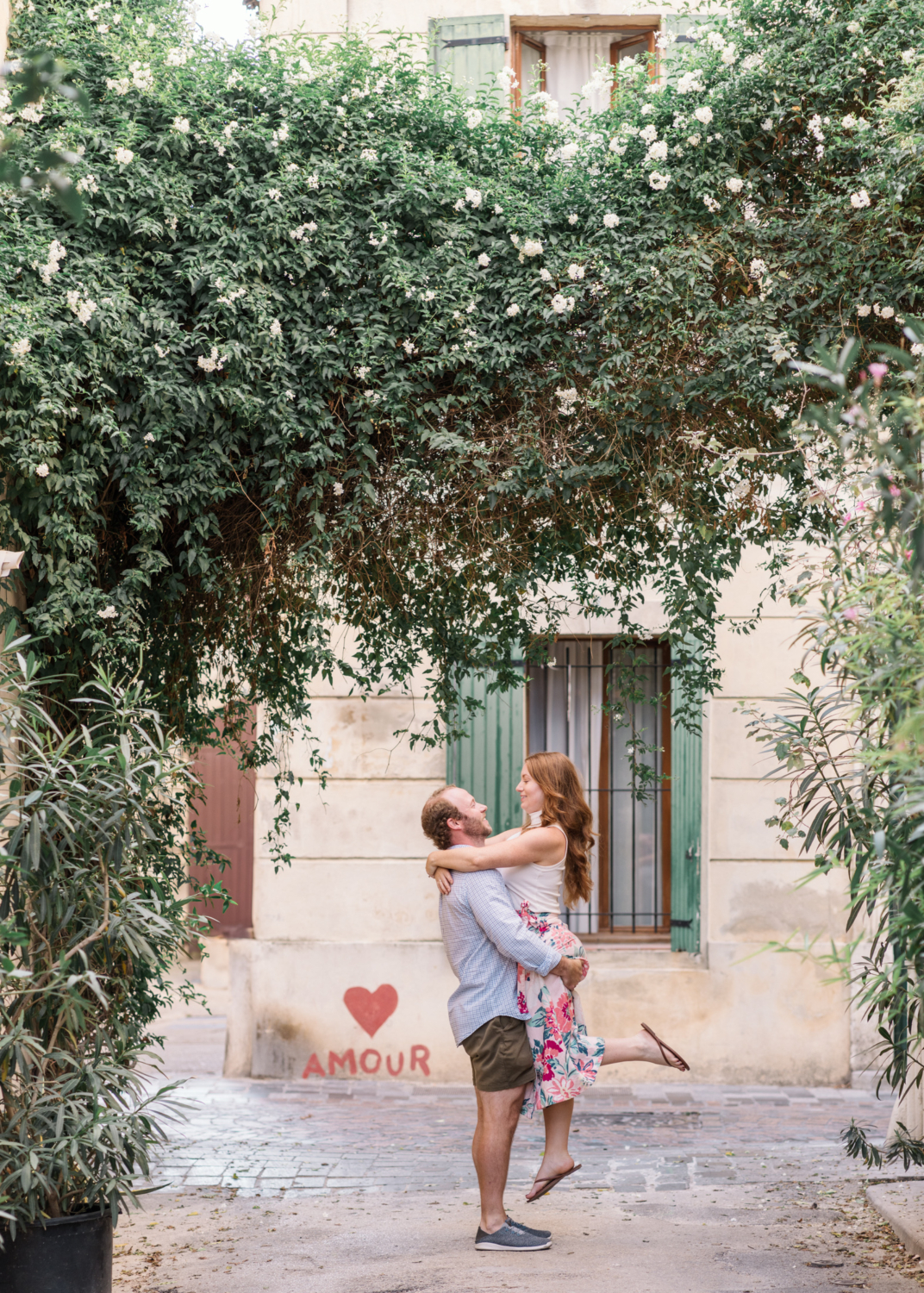 husband lifts wife on the streets of arles france