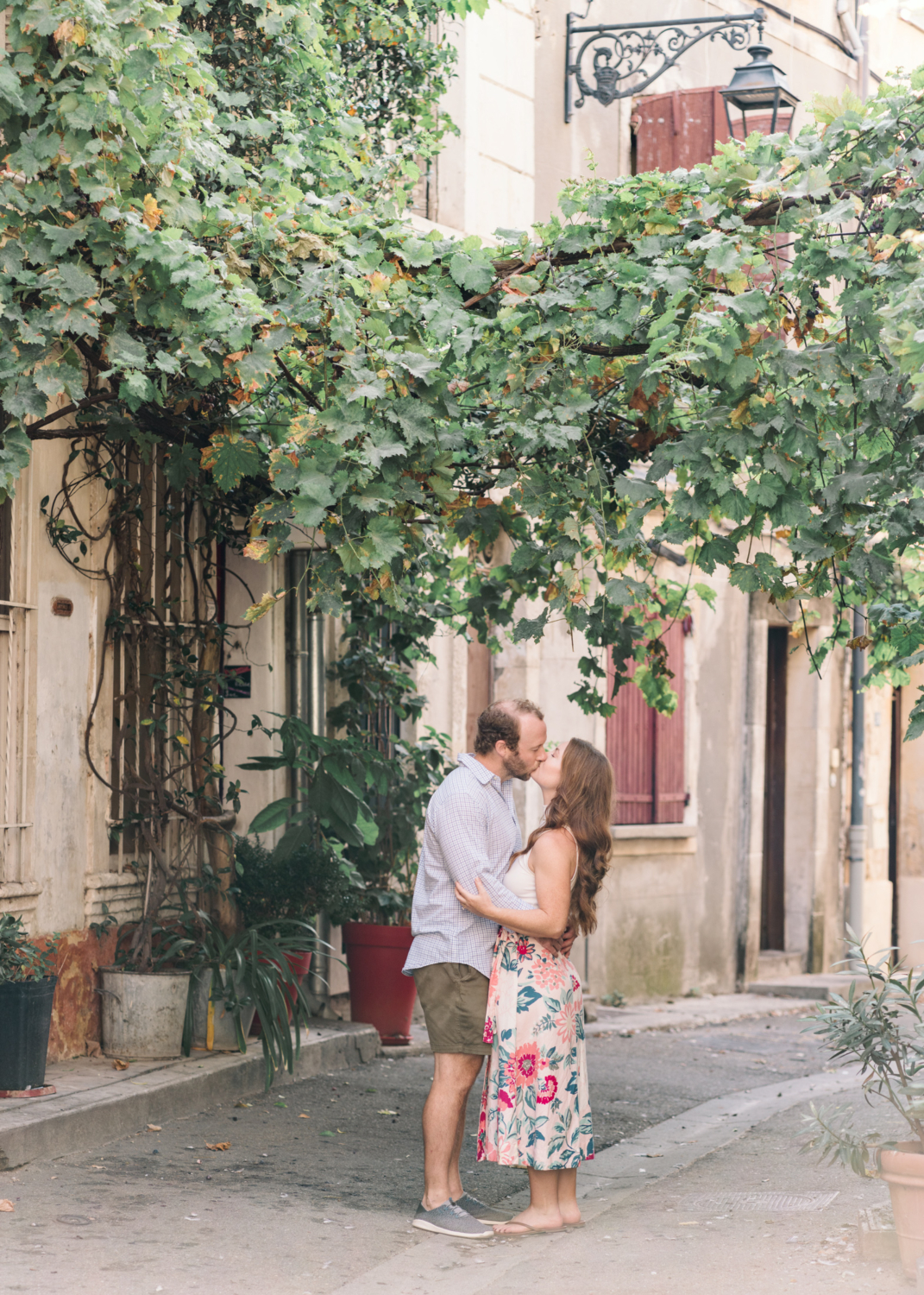 romantic couple kisses under grape tree in arles france