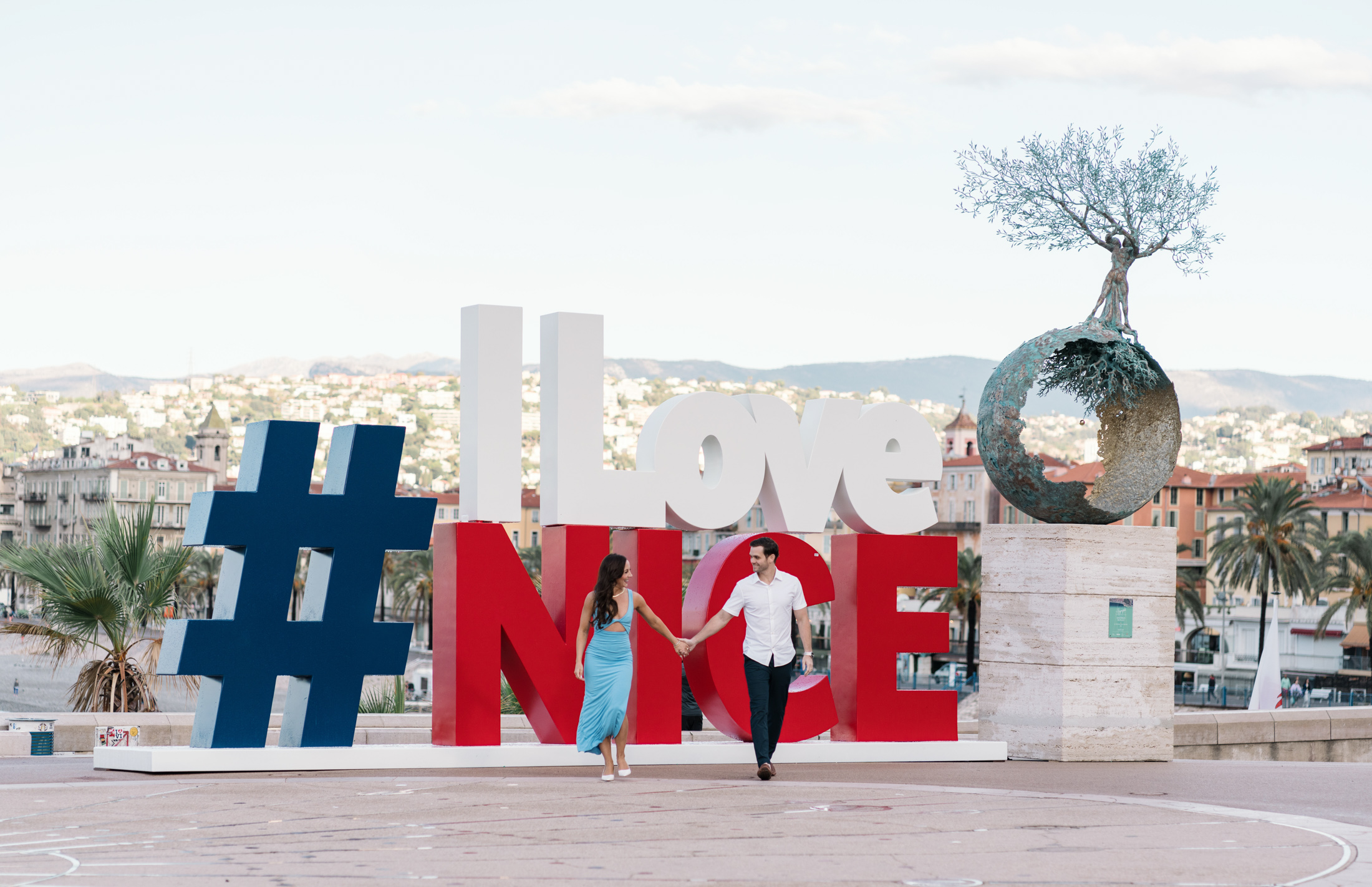 cute newlywed couple walk hand in hand with the i love nice sign