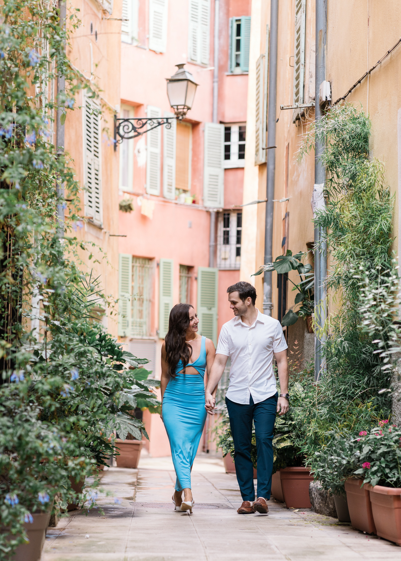 beautiful newlywed couple smile and walk through the streets of old town nice france