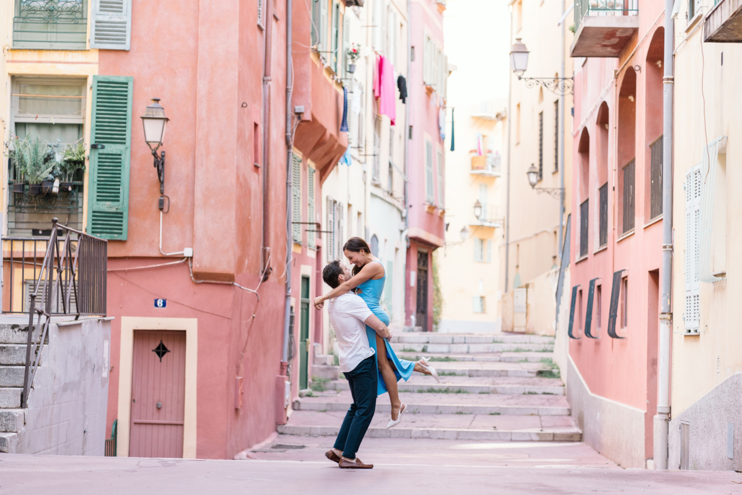 newly married couple laugh and dance on the streets of old town nice