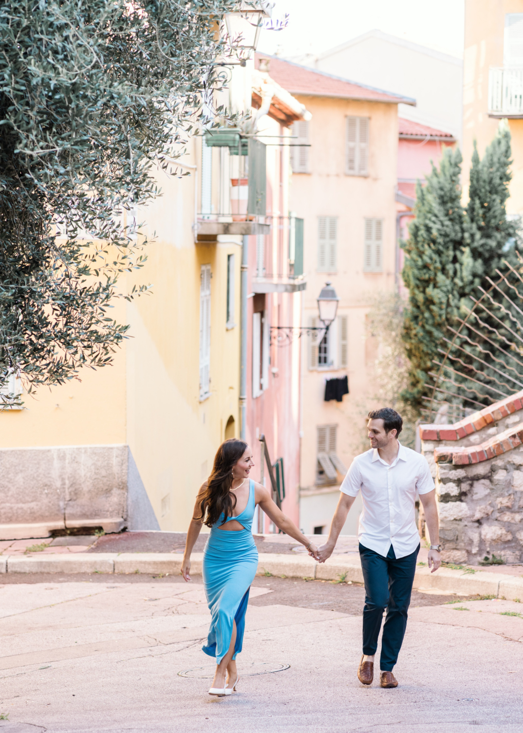 honeymooners laugh and walk together in old nice france