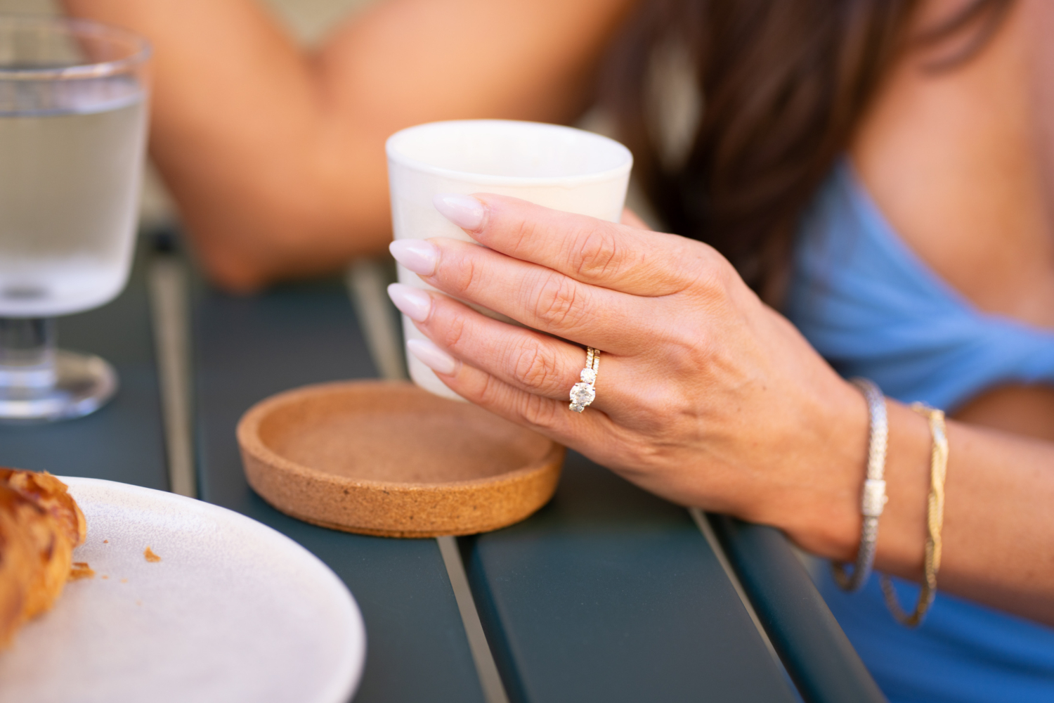 woman shows off wedding ring holding espresso in nice france