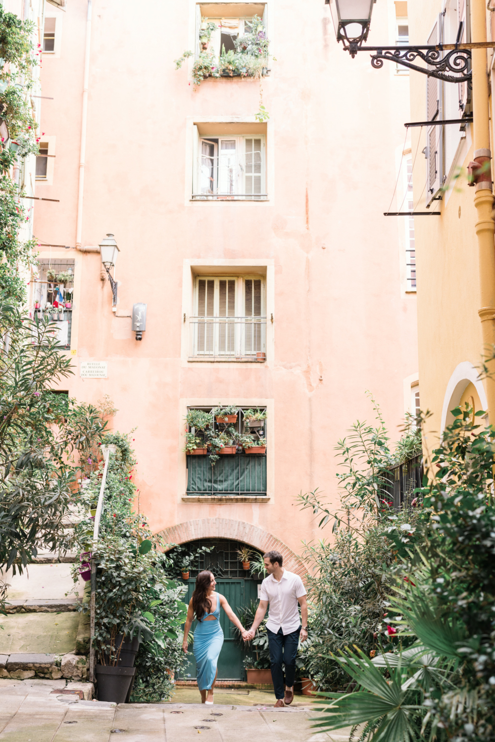 honeymooners walk in front of pink building in old town nice france