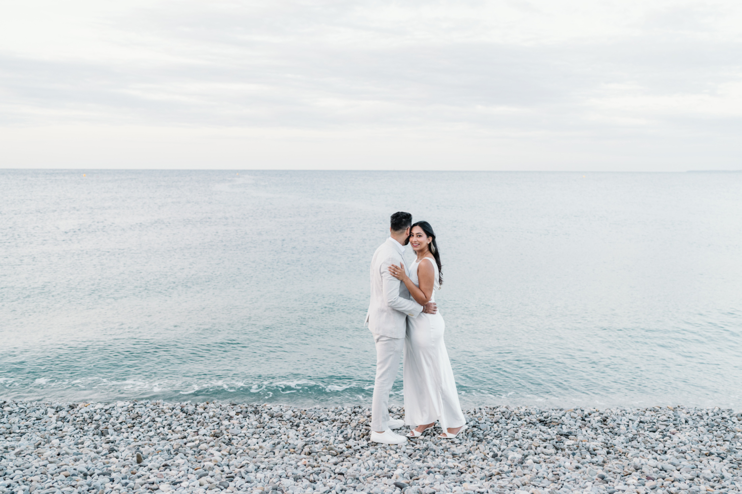 indian american couple embrace next to the sea in nice france