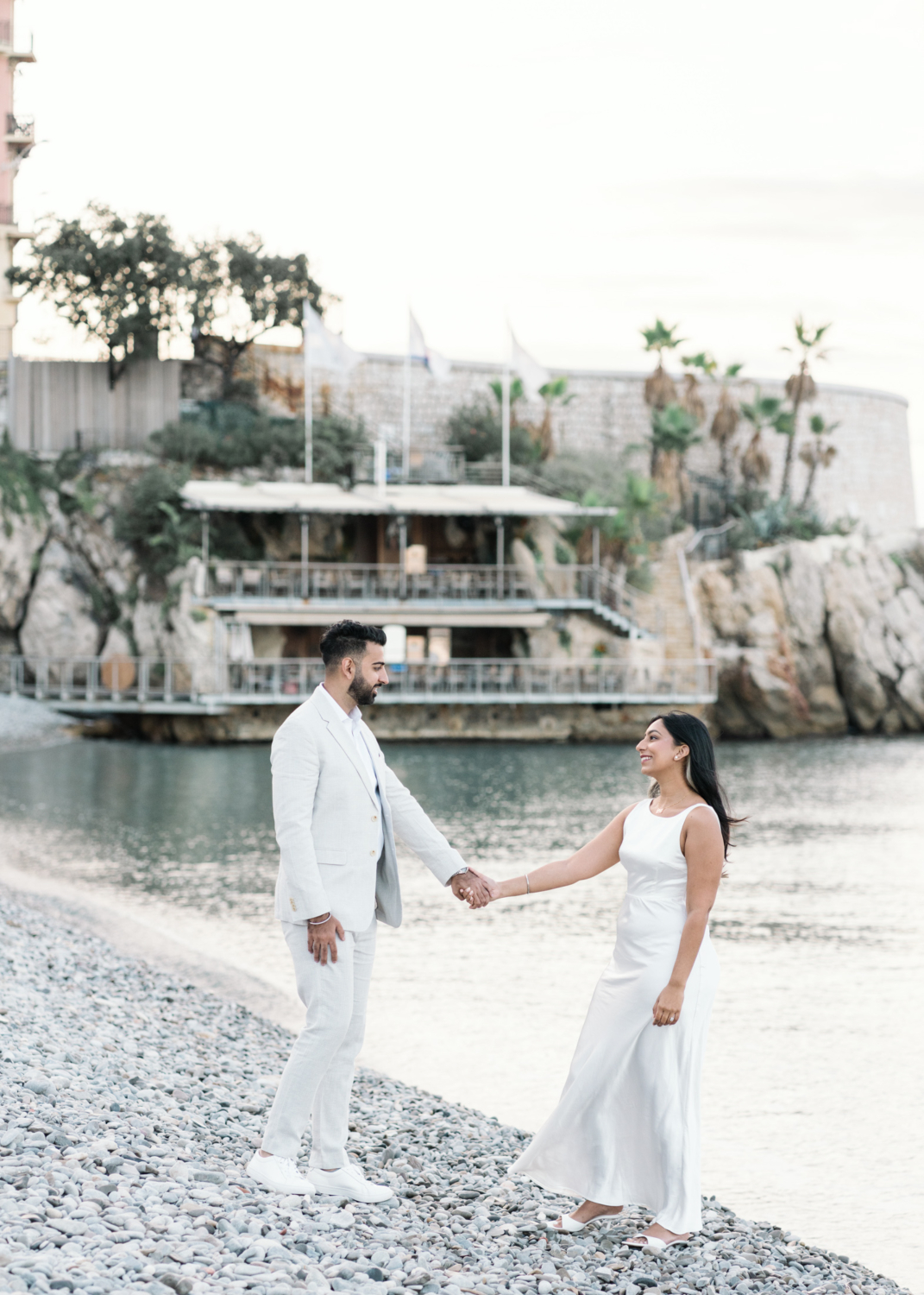 newly engaged couple hold hands in nice france by the water