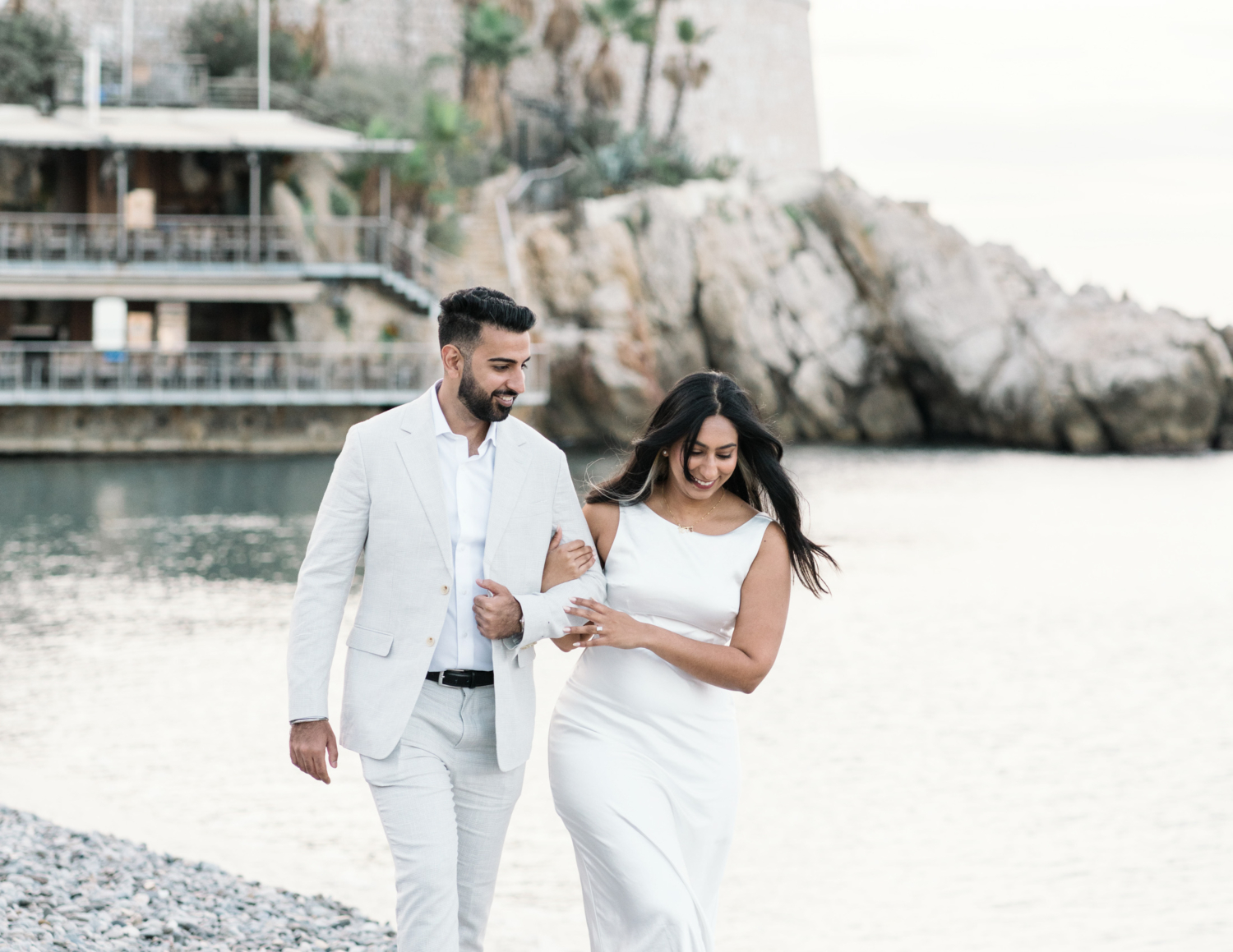 gorgeous indian american couple laugh and walk on the beach in nice france