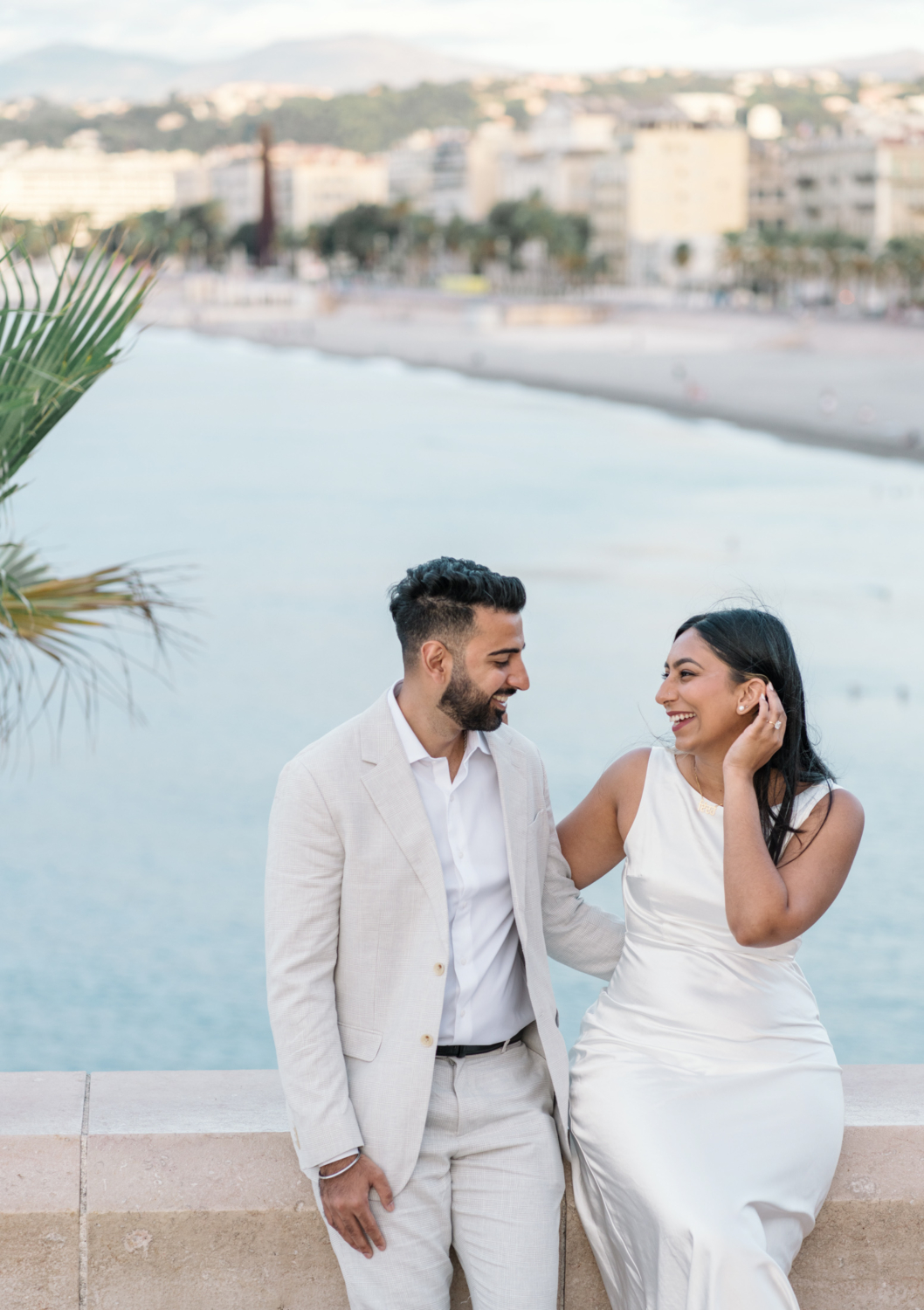 engaged couple laugh with view of sea in nice france