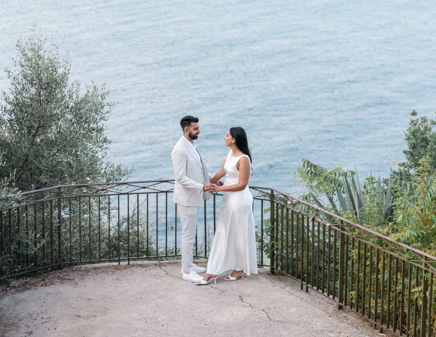 beautiful indian couple hold hands in nice france with view of sea