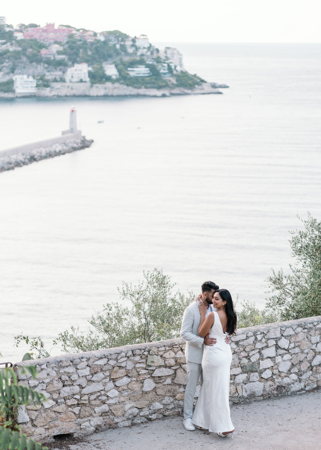 gorgeous engaged indian couple embrace with view of sea in nice france