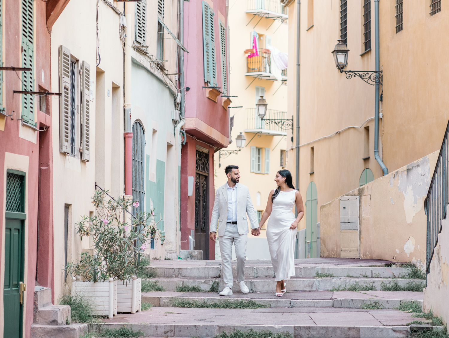 beautiful engaged couple walk and smile in old town nice france