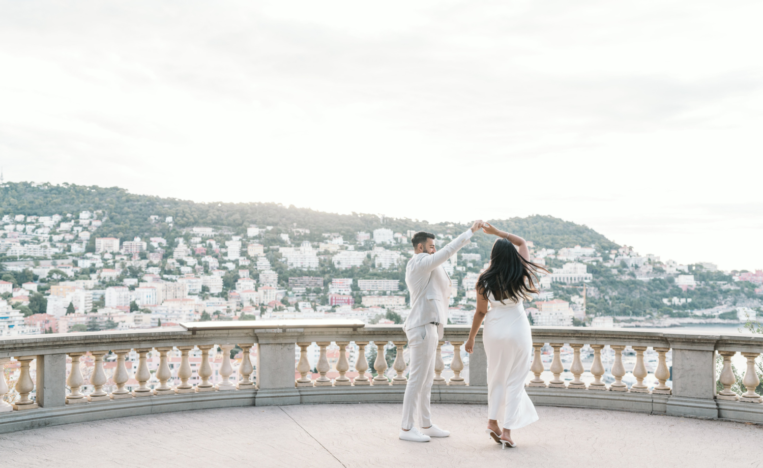 man twirls woman during engagement photo session in nice france