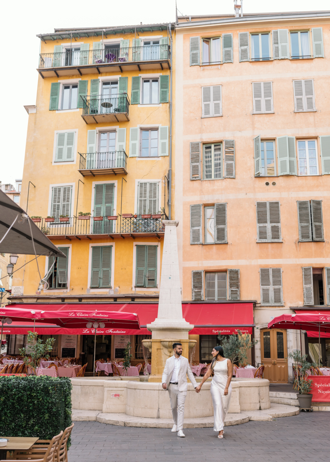 indian american couple walk in front of fountain in nice france